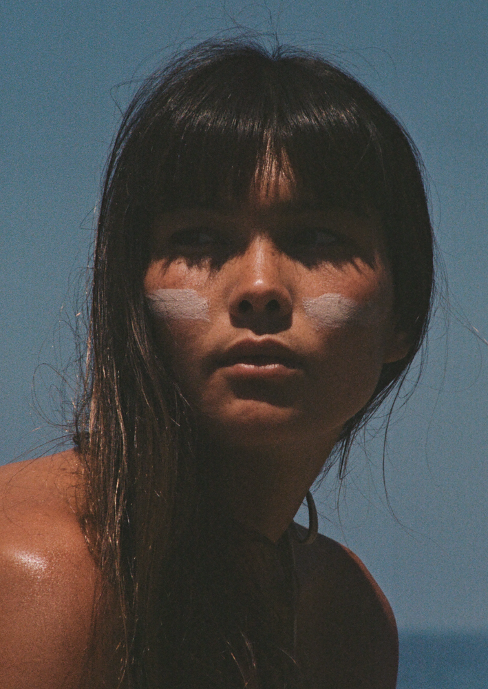 Woman with stripes on her face showing the texture and colour of our Our all natural tinted Surf Balm Sunscreen features broad spectrum SPF 30 sun protection without the use of chemical UV filters, preservatives, emulsifiers, silicones, nano-particles, micro-plastics, animal testing, phthalates or parabens. Crafted with four powerful ingredients which work together to protect and nourish your skin in harsh conditions.